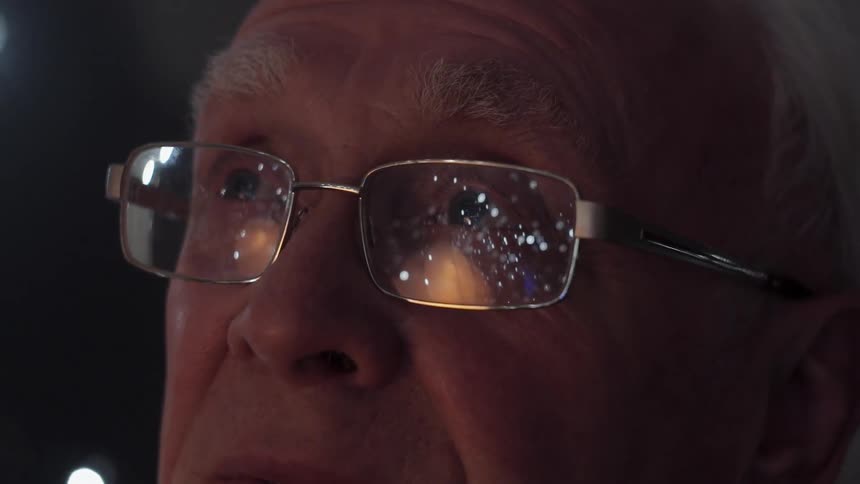 A man with glasses watching the sky