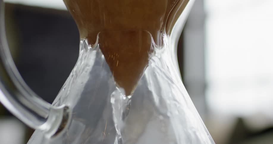 Water pouring through a coned filter into a glass container