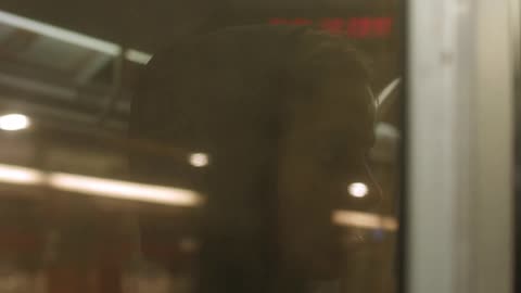 A man looks through a subway window