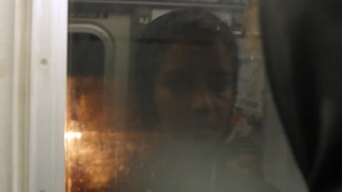 A woman is riding the train at night