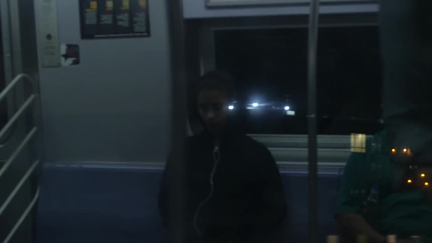 Woman in black hoodie riding on the subway