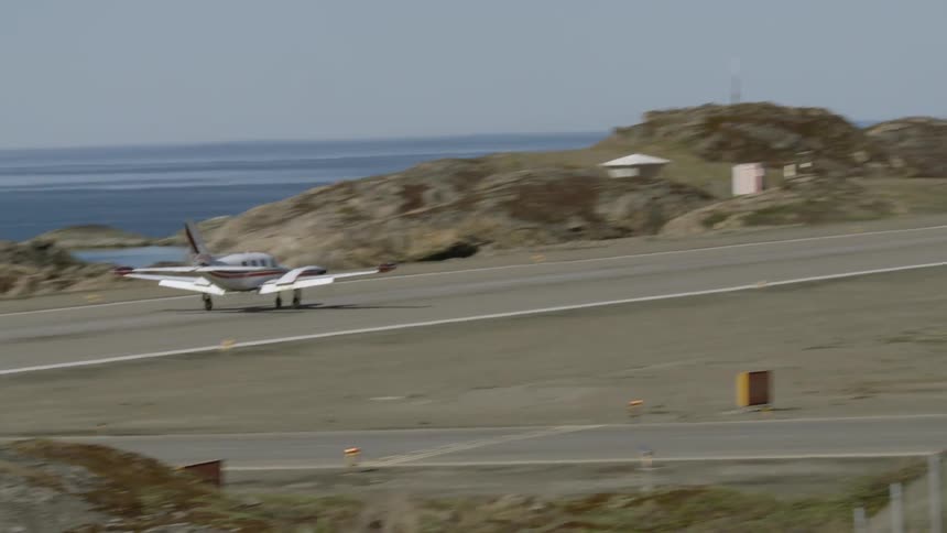 An airplane touches down on a landing strip
