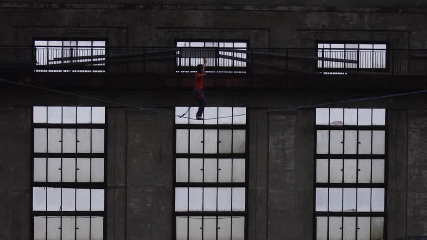A person is walking across a wire