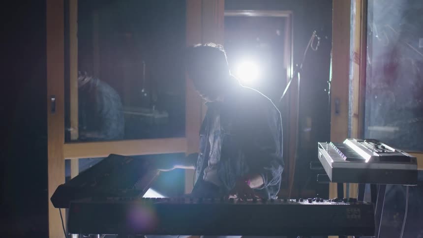 Person playing the keyboards in a studio
