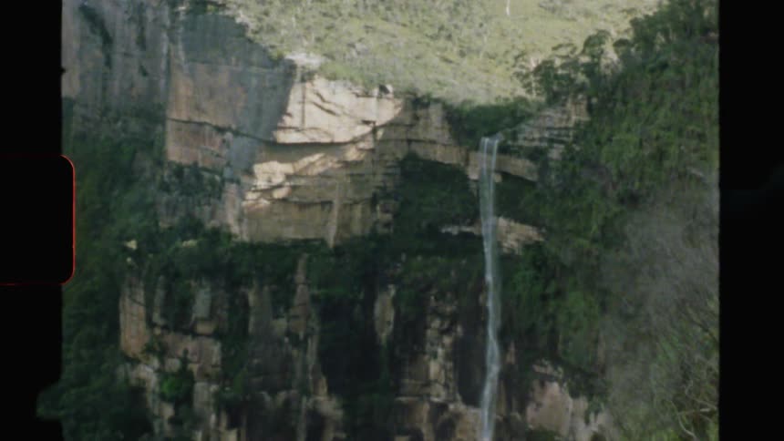 Water flows down the cliff face of a canyon rock wall