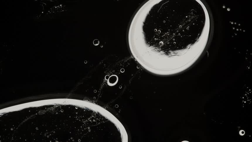 Bubbles with white outlines are moving across a black area
