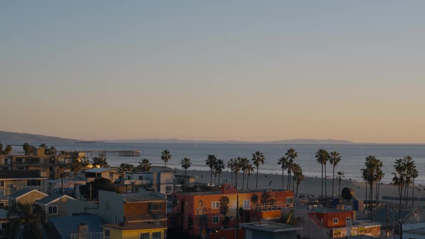Buildings and homes on a sandy beach at sunset