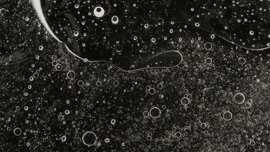 Abstract air bubbles in liquid flows down on black background