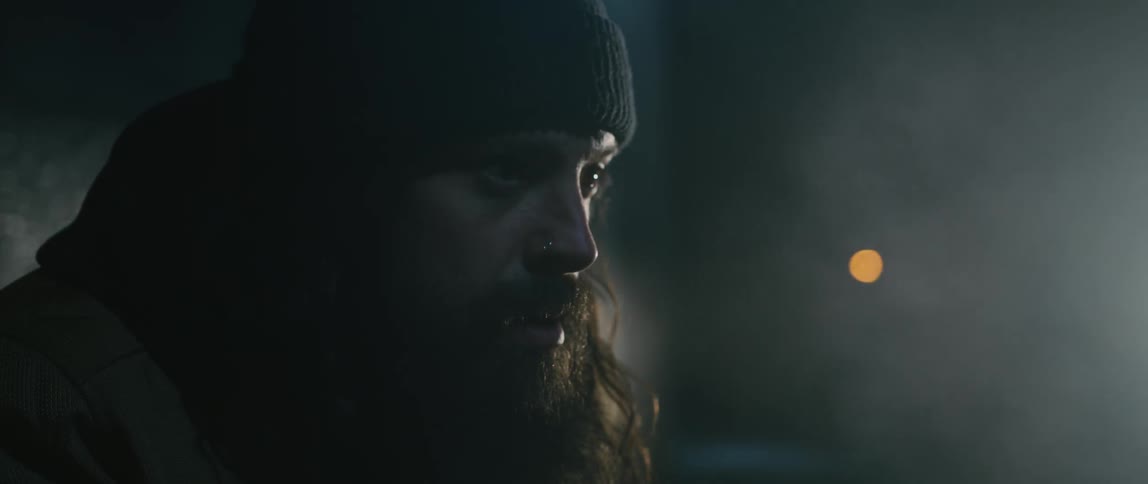 A man breathes cold air while standing outside at night