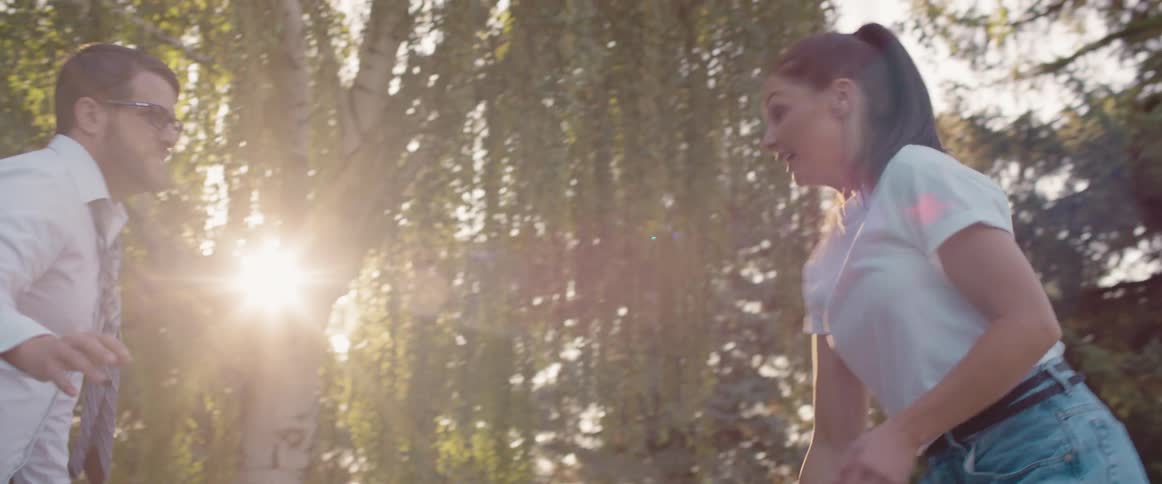 Man and woman play basketball near the forest on a sunny day