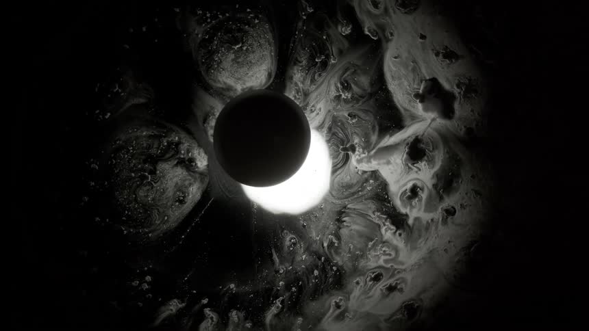 A black circle partially covers a glowing circle surrounded by an abstract pattern