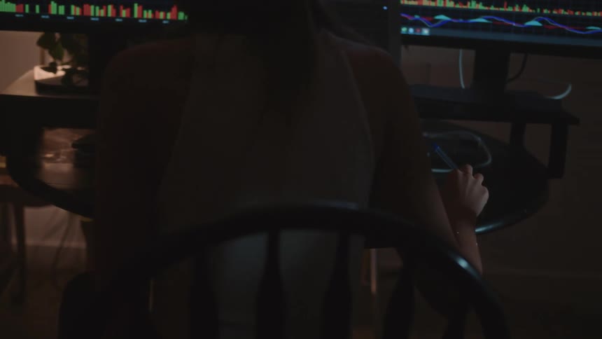 A woman in a an office points at her computer as she works