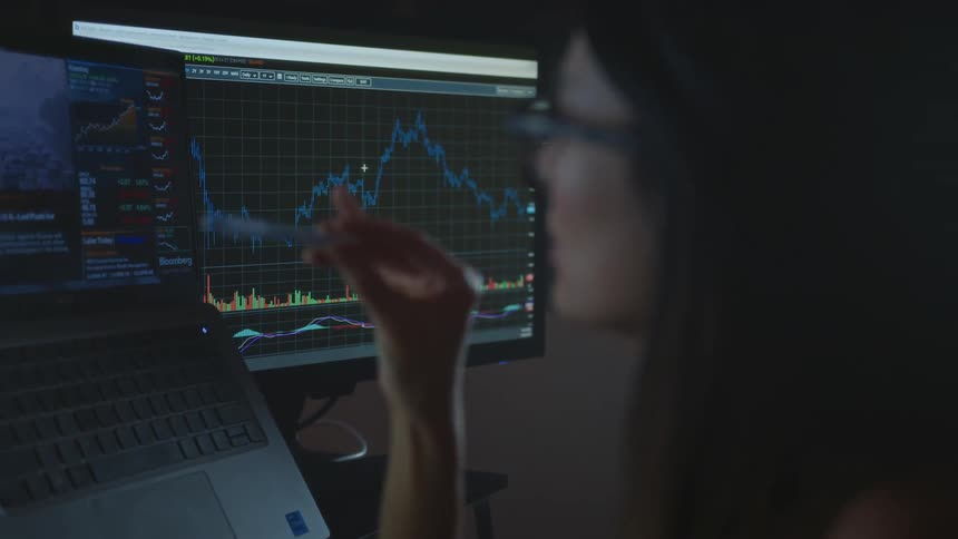 A woman looking at computer screens in an office