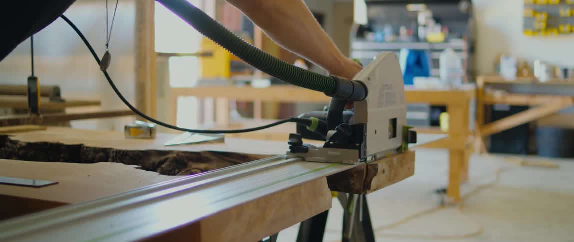 A person cuts wood with a table saw