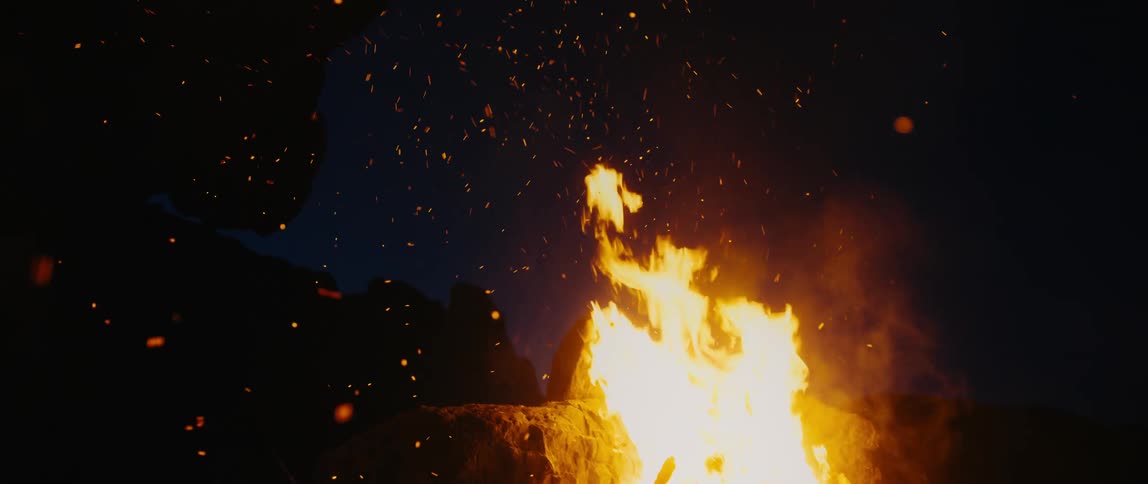 The campfire burns at night