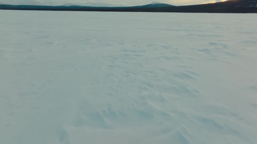 Snow covers plains to the mountains on the horizon