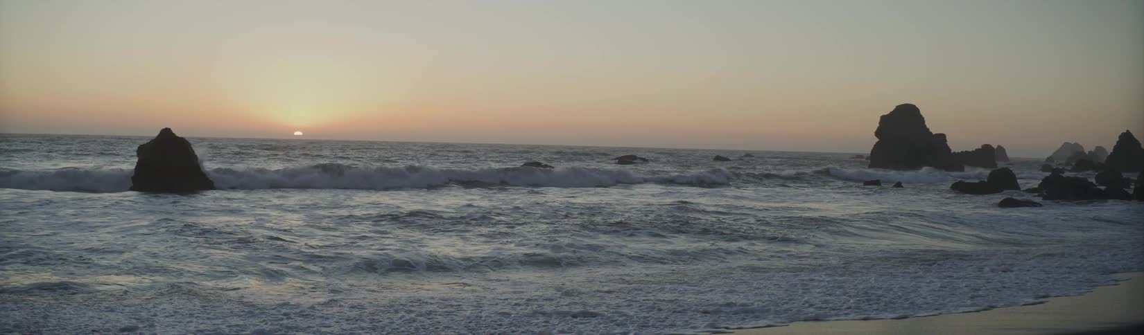 Waves roll in to the shore as the sun sets