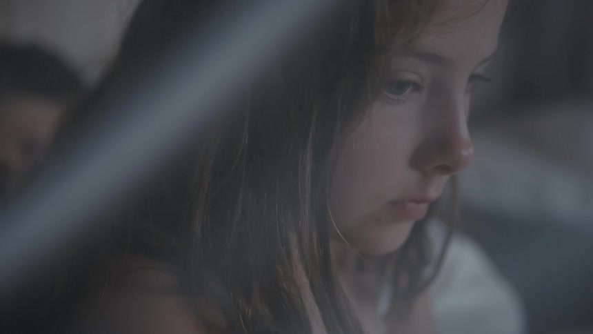 Teenaged girl with long hair talks as she looks pensive