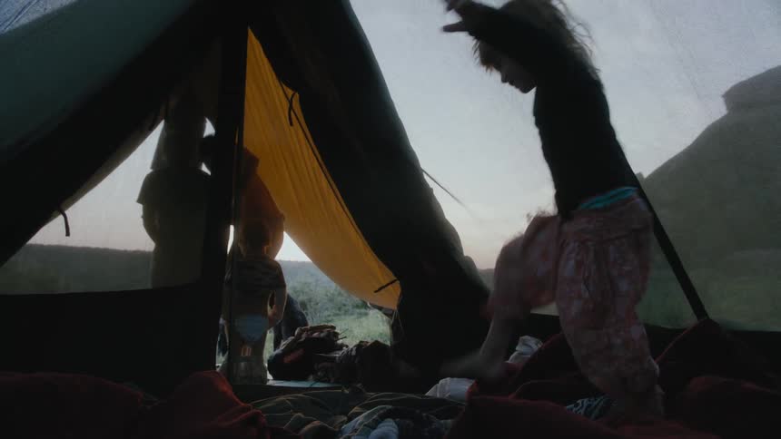 A child walks out of the tent