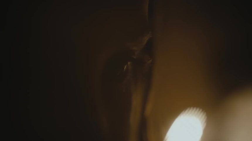 A woman sits in a dimly lit room