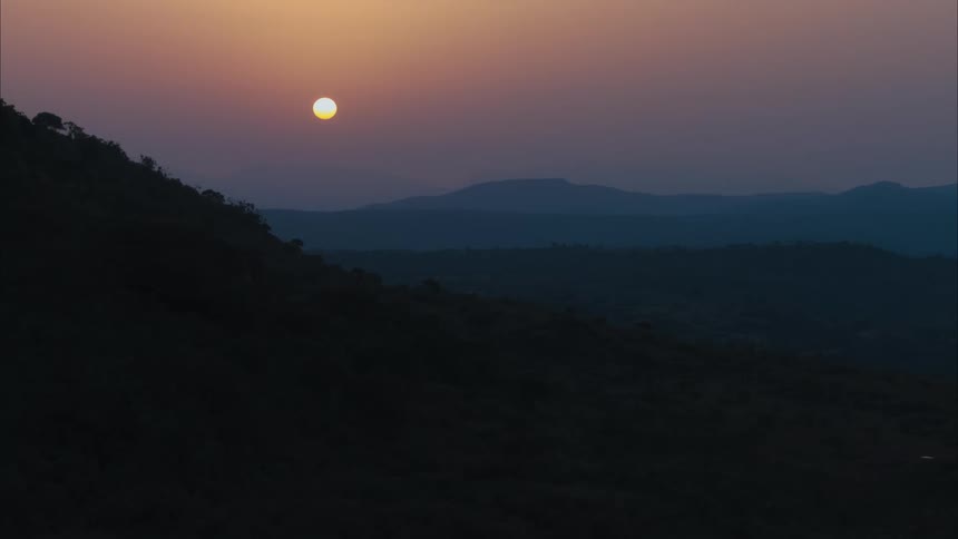 Aerial view of the sun setting over the hills in the badlands