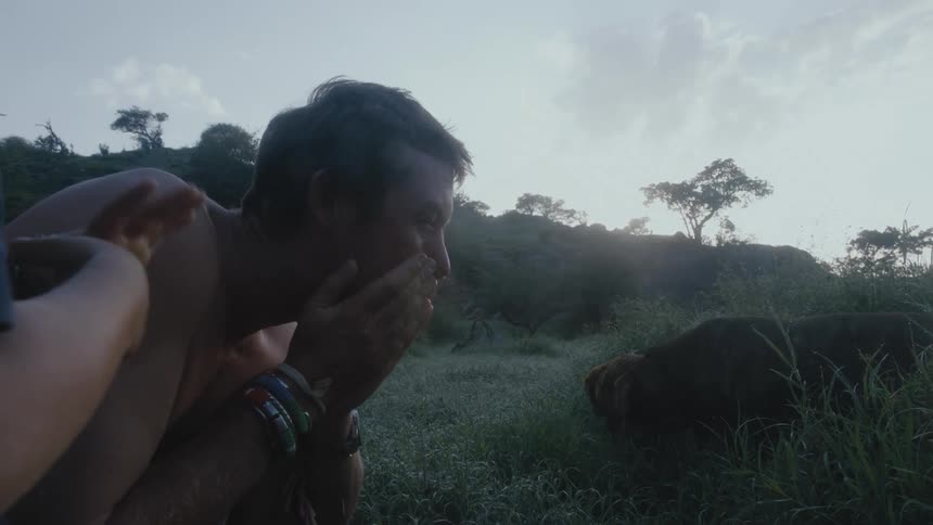 A man is washing his face outdoors in the wilderness