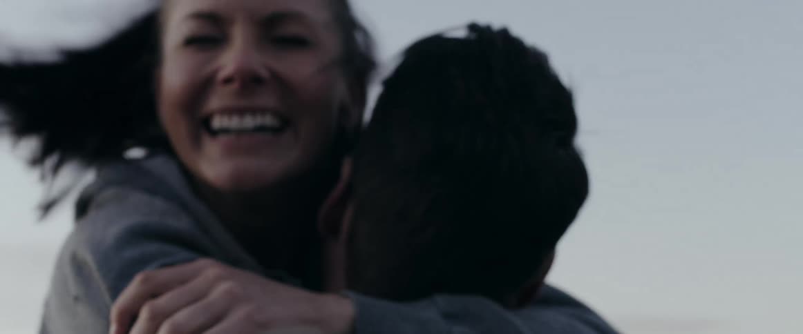 A man proposing to a woman with a diamond ring on a hilltop