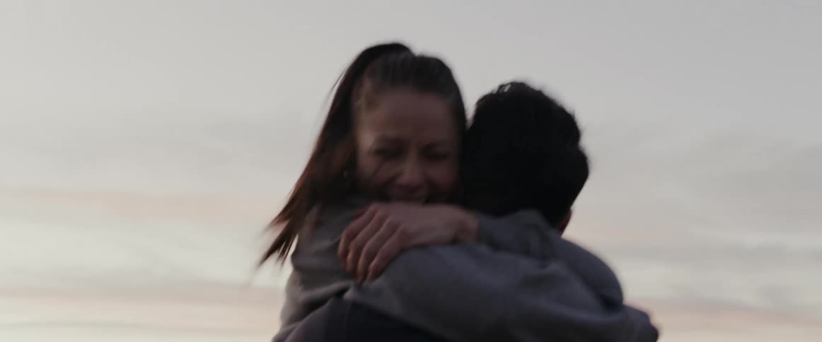Man proposes to his girlfriend and she happily says yes in a hill at the outskirts of a city