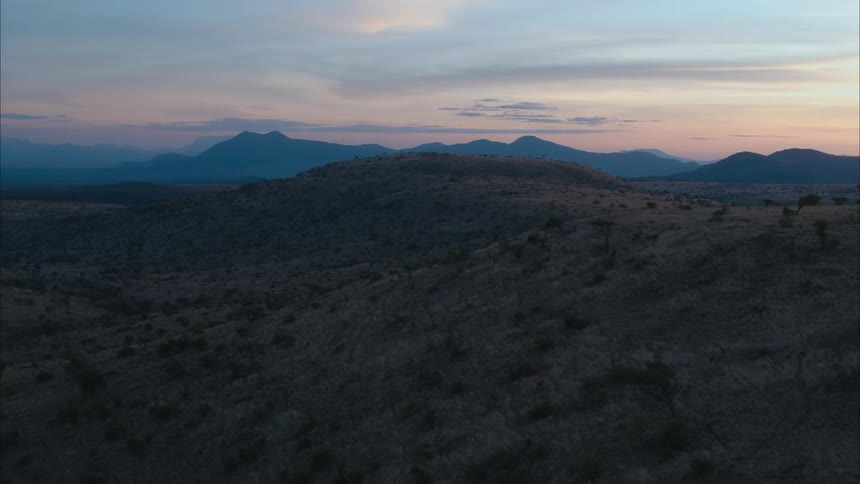 An aerial view of hills and mountains in nature at sunset