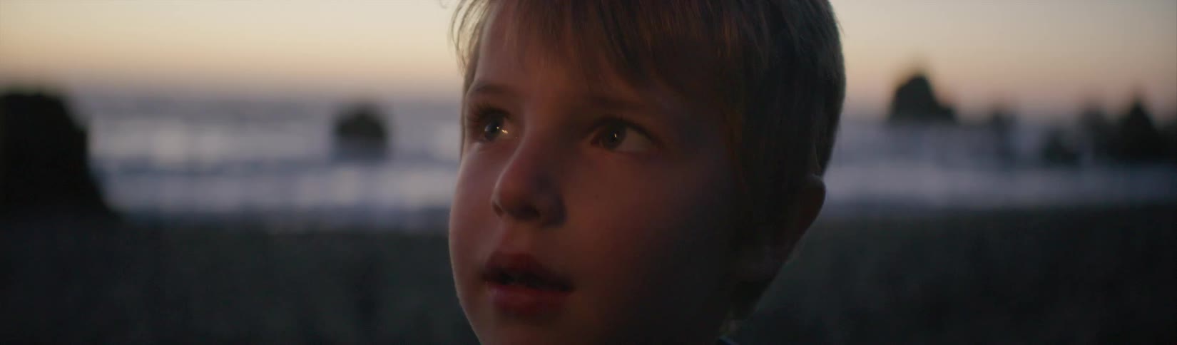 A child looks around on the beach