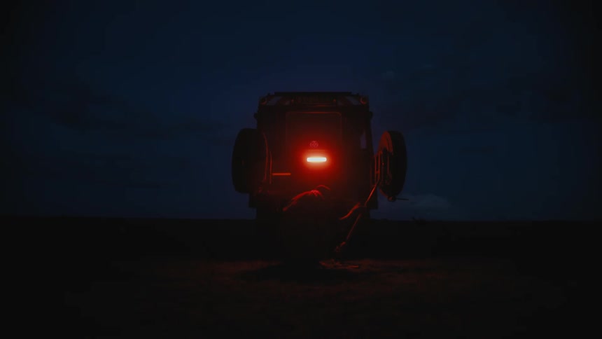 A person is outside of their vehicle at night