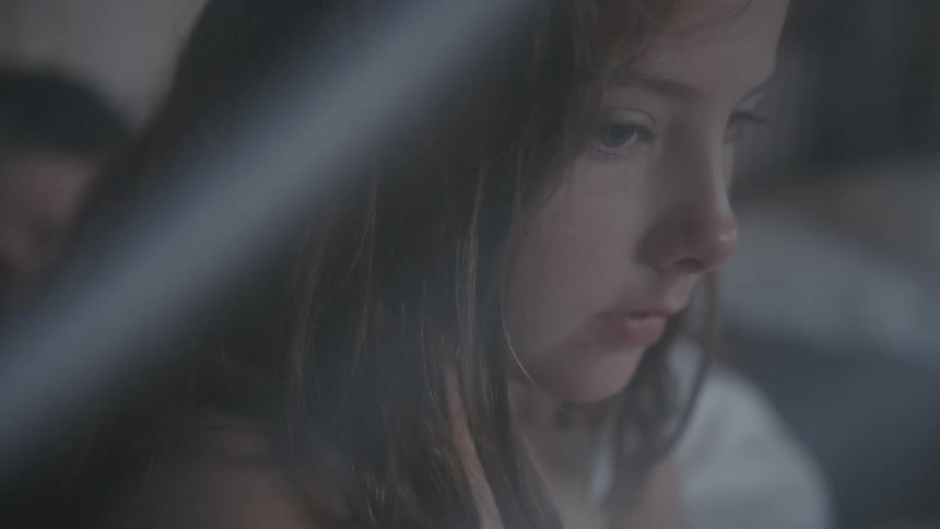 Side portrait of girl with brown hair talking to person