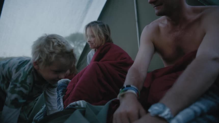 Family of with children camping on a translucent tent in the countryside at morning