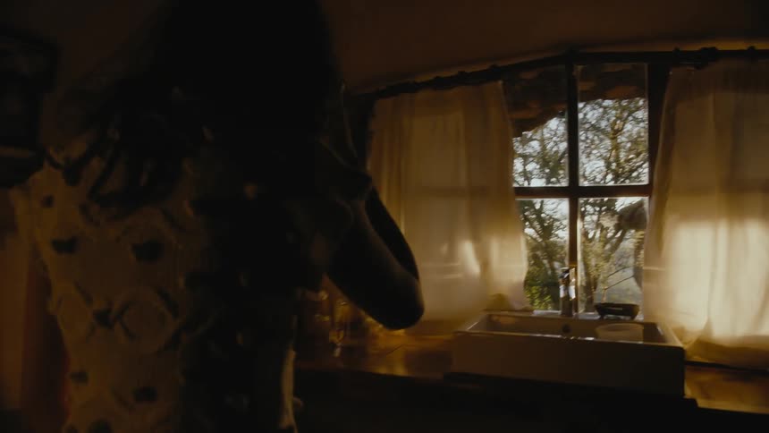 A woman is walking around her house during the day