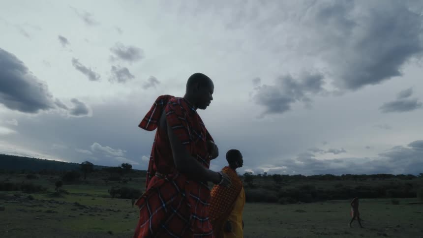 Two people are walking in the wilderness during the daytime
