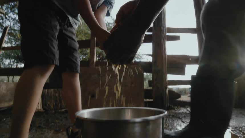 A boy helps a man clean up on a farm