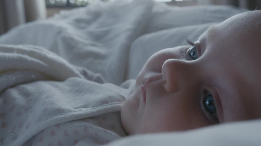 Baby lying with its eyes open