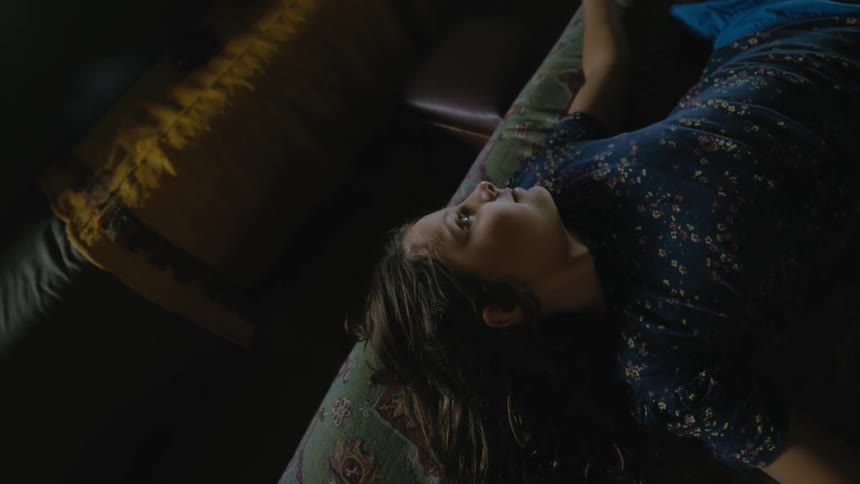 Girl lies on her back on bed smiling and moving about