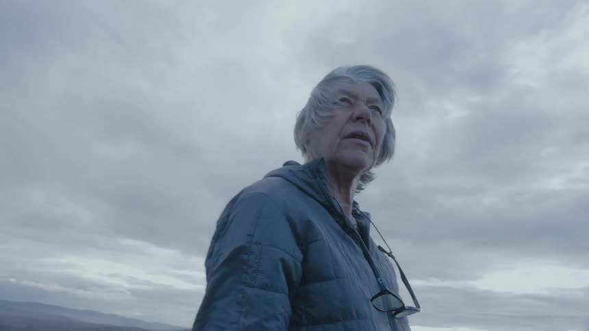 A woman is hiking outdoors at dusk