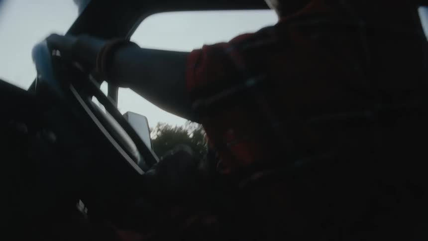 Black man driving a car in a forest area