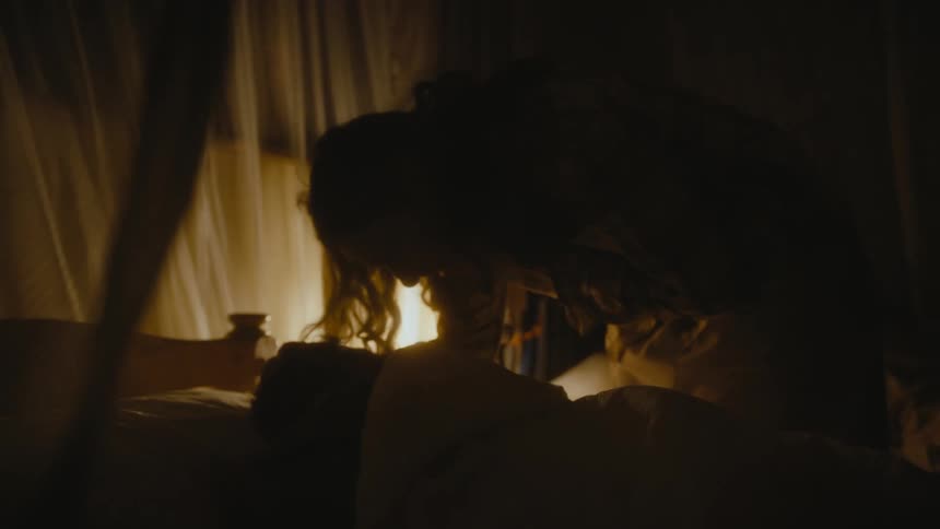 Mother kissing the head of one of her children that is sleeping in the childrens bedroom