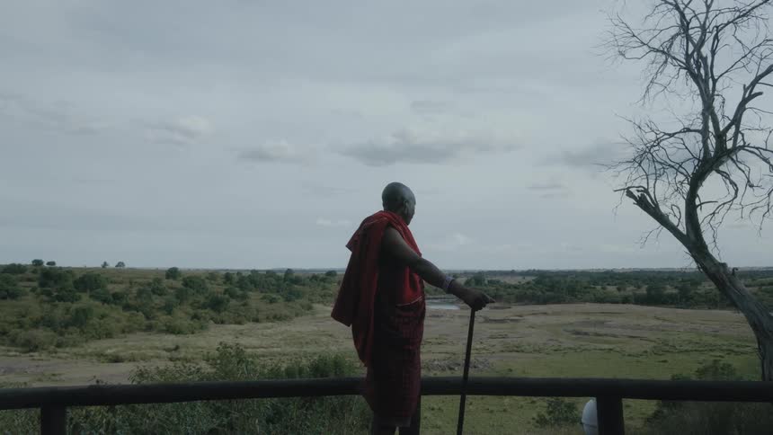A man stands and looks out at the land in front of him