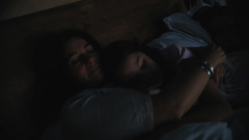 Mother and daughter lying in the bed while cuddling each other