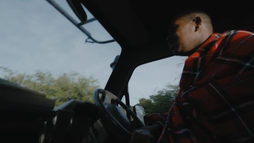 Black man driving a car through a safari