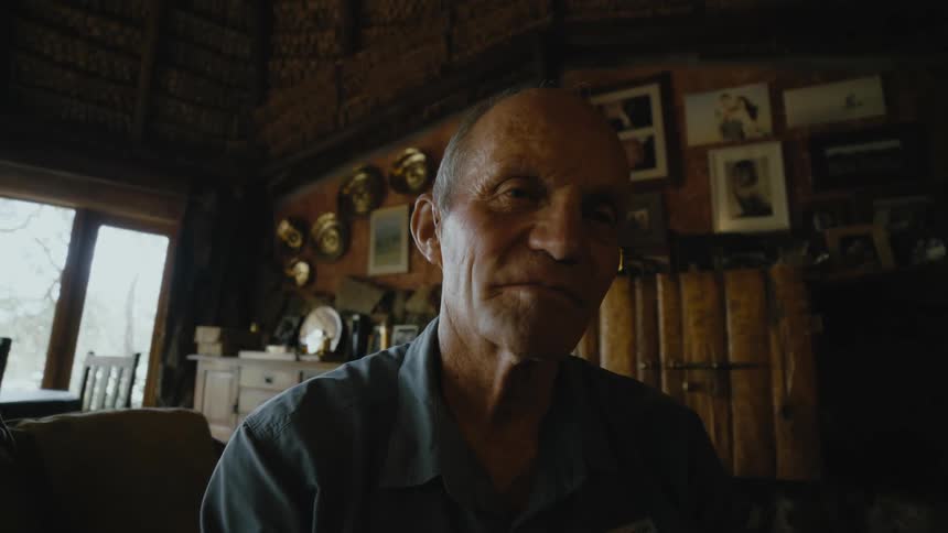 An elderly man sitting on a chair at home