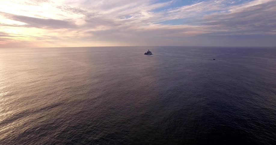 Aerial view moving away from a small island in the ocean