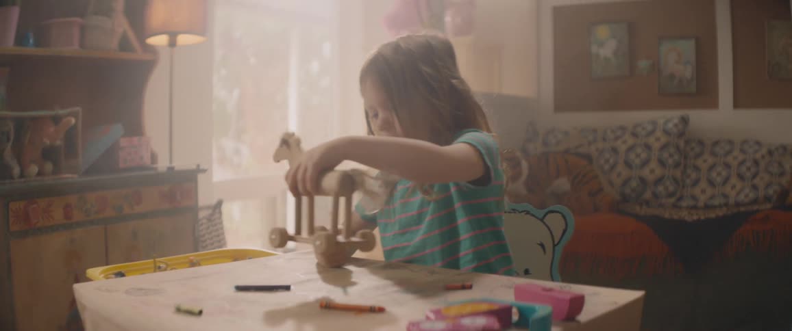 A little girl playing with a wooden toy horse