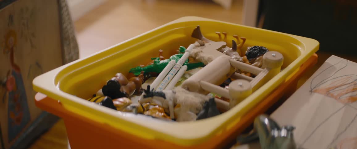 A shallow plastic bin is filled with a wide variety of small toys and trinkets