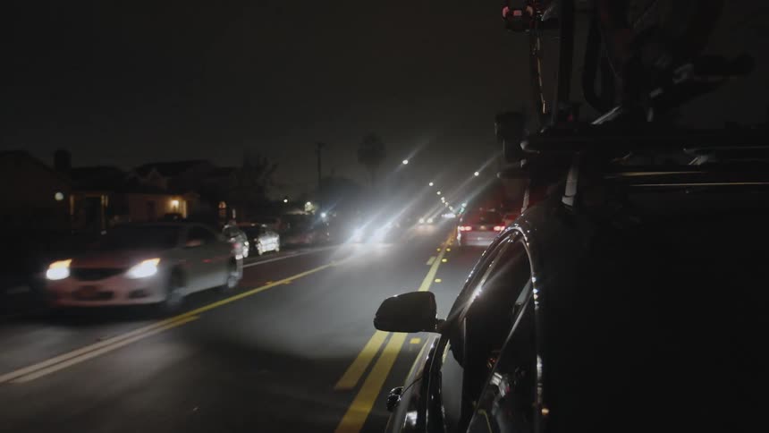 Cars driving down a road at night