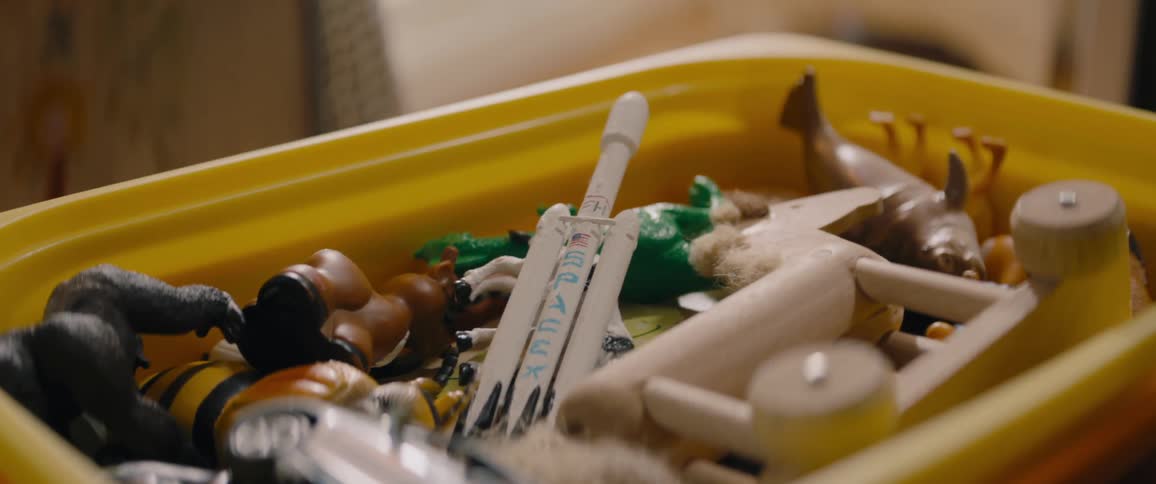 A plastic bin is filled with toys